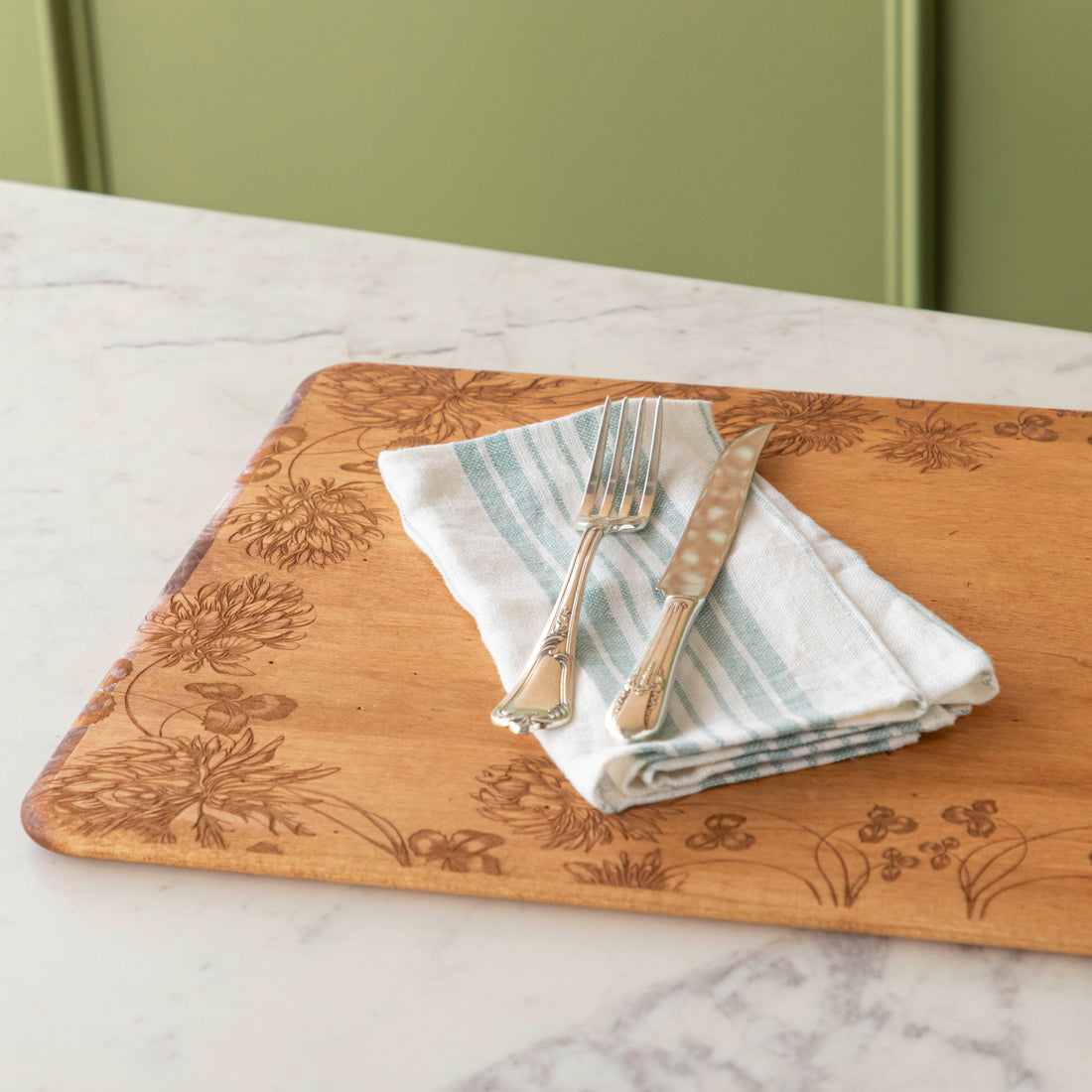 24 x 14 x 0.6 in maple artisan charcuterie board with heirloom distressed finish and hand-engraved clovers on a white background.