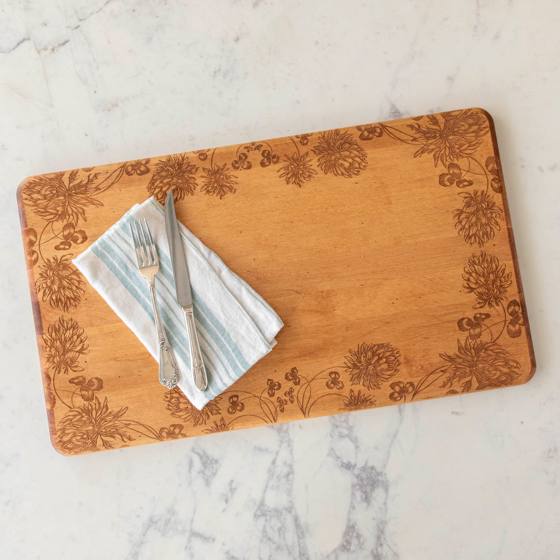 24 x 14 x 0.6 in maple artisan charcuterie board with heirloom distressed finish and hand-engraved clovers on a white background.
