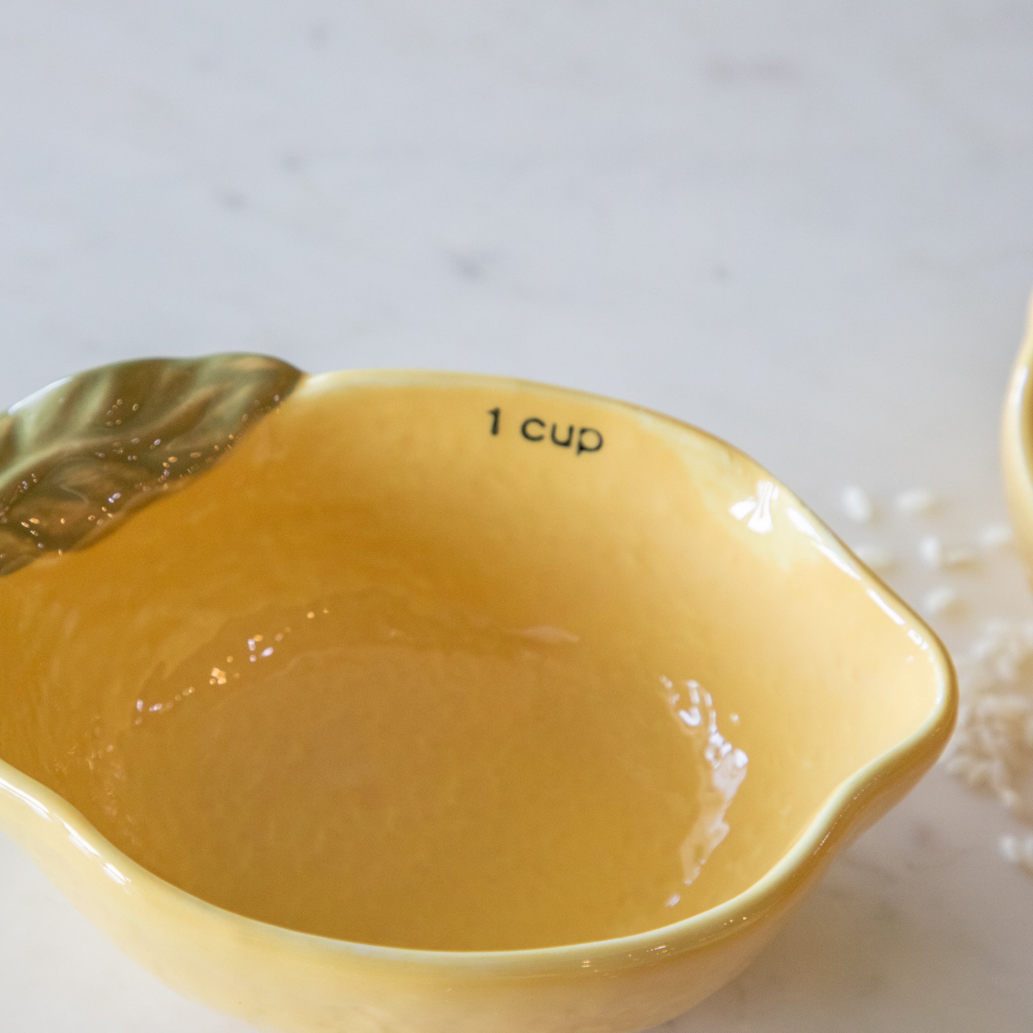 &quot;1 cup&quot; in black ink on the inside of the lemon measuring cup and a lip for pouring.