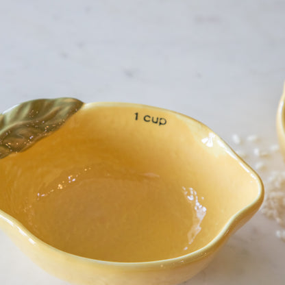 &quot;1 cup&quot; in black ink on the inside of the lemon measuring cup and a lip for pouring.