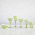 A set of SIR/MADAM Rialto Pale Sage Glasses and a bowl on a marble table.