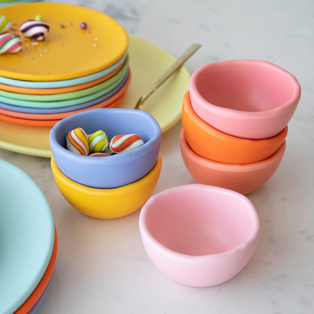 A set of colorful, dishwasher-safe Glitterville Rainbow Melamine Trinket Bowls on a table.