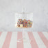 A HomArt Glass Dome & Pedestal cake stand with a glass dome lid filled with sprinkle-covered cookies on a pink and white striped surface.
