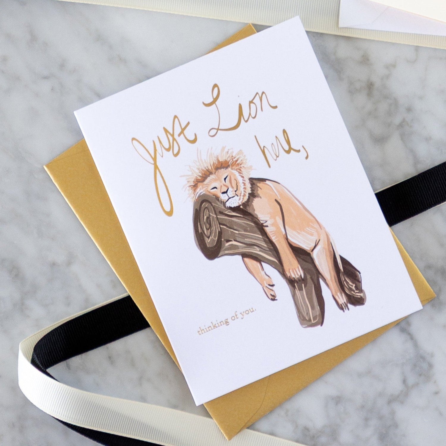 Good Juju Ink cards with black and white ribbon on a table.