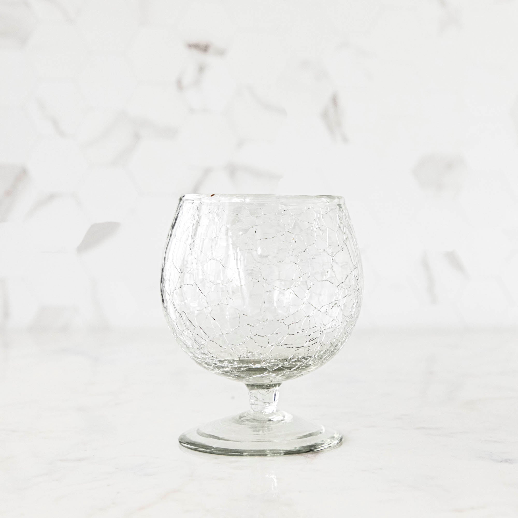 A glass of wine on a table next to Norwell Goblets by Design Ideas.