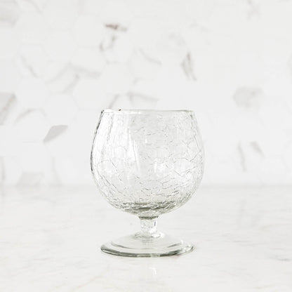 A glass of wine on a table next to Norwell Goblets by Design Ideas.