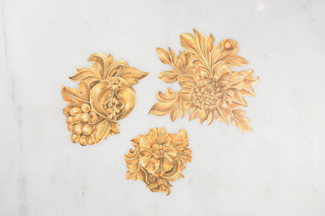 Three die-cut paper serving papers featuring illustrated gold floral embellishments for your table.