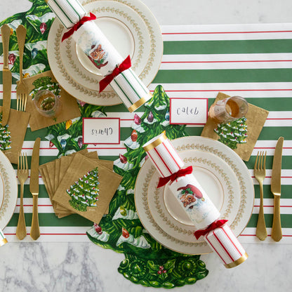 The Green &amp; Red Awning Stripe Runner under a table setting featuring the Die-cut Christmas Tree, elegant plates with the Santa Crackers atop, Red Frame Place Cards, and Christmas Tree Cocktail Napkins.
