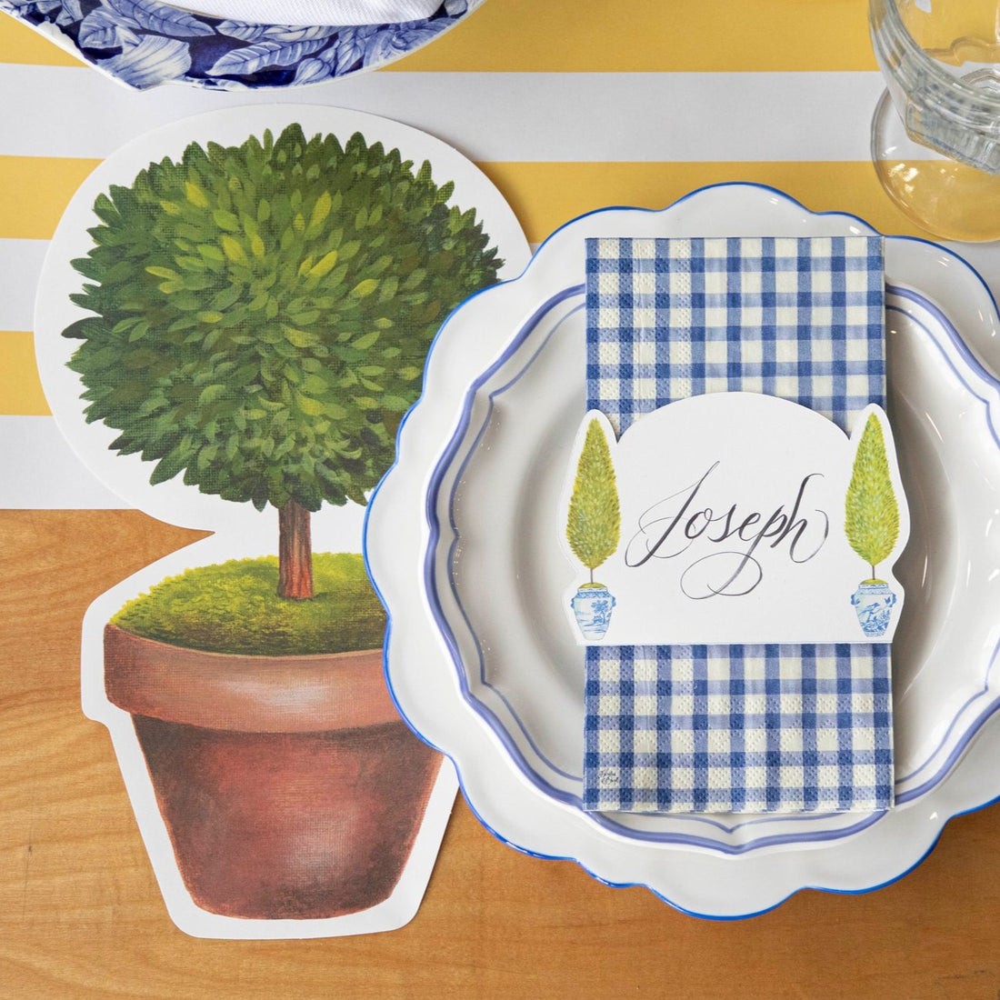 Two Die-cut Topiary Pair Placemats on a table with placemats on a white background. (Brand: Hester &amp; Cook)