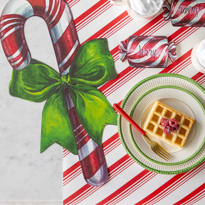 The Christmas Candy Place Card reading &quot;Jerry&quot; next to the Die-cut Candy Cane Placemat and behind two stacked plates with waffles and a fork on it.