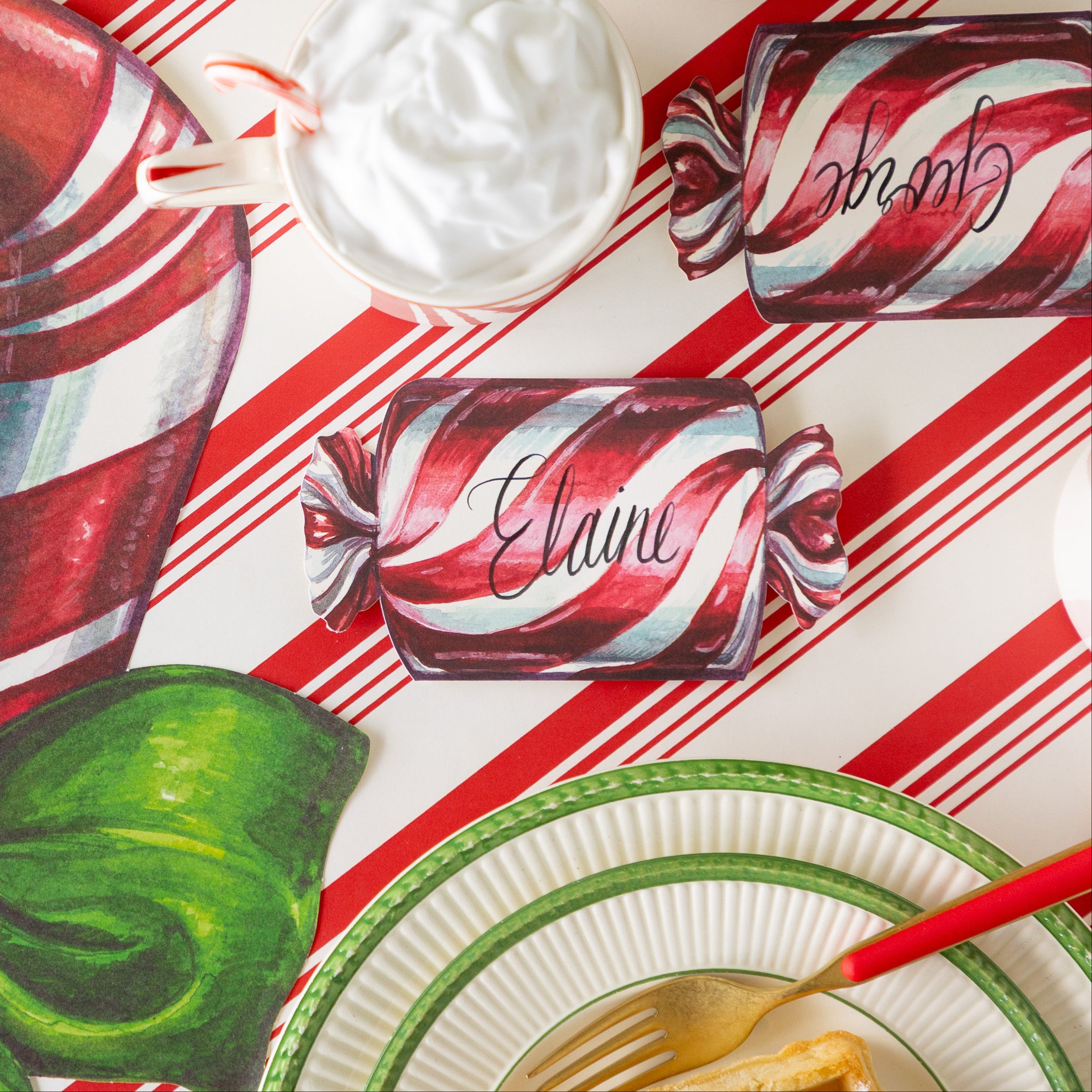 The Christmas Candy Place Card reading &quot;Elaine&quot; behind a place setting, on the Peppermint Stripe runner.