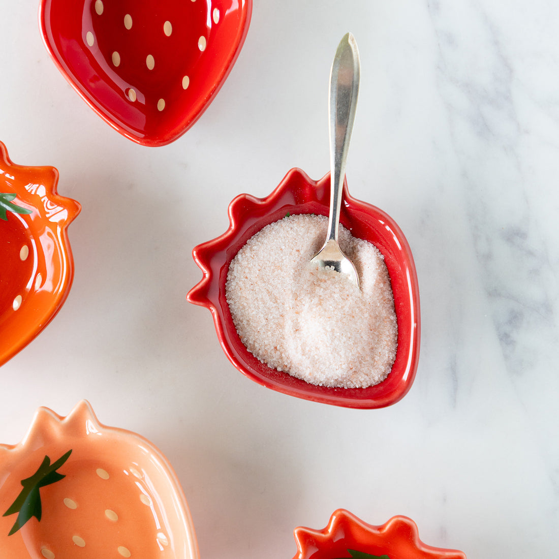 A Berry Sweet Shaped Pinch Bowls filled with sugar and a spoon.