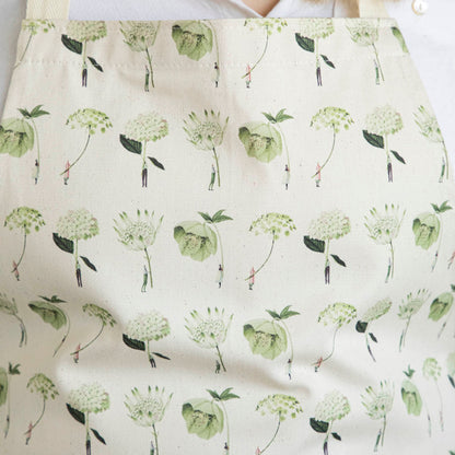 Close-up of a woman wearing the Green Flowers Apron by Laura Stoddart.