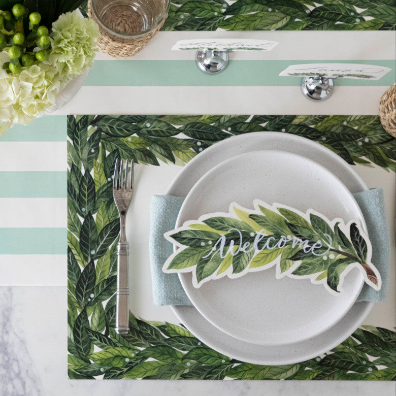 An elegant table setting for four featuring Laurel Table Accents resting on each plate.