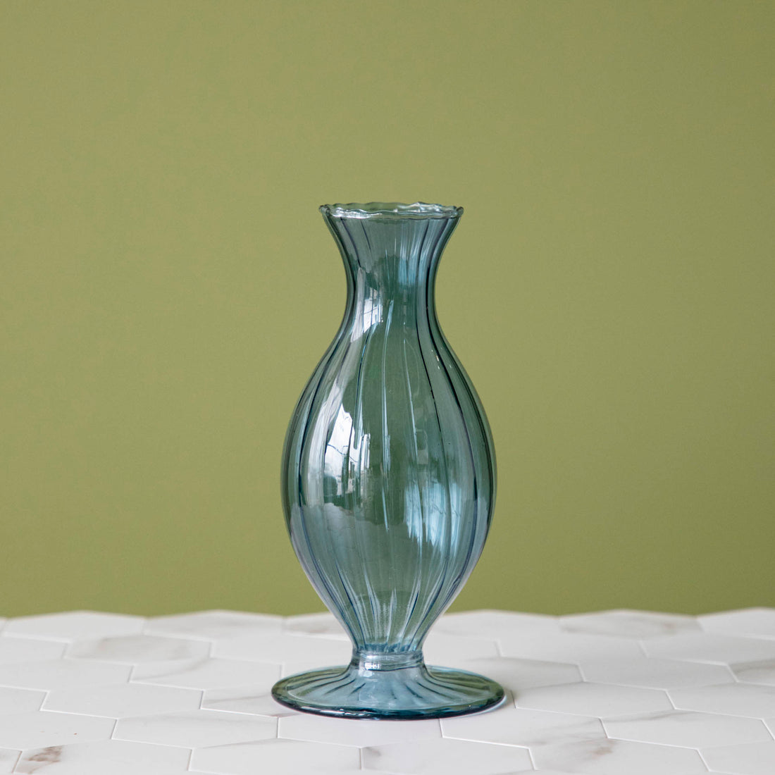 A Blue Vintage Boutique Vase by Accent Decor sitting on top of a table.