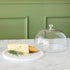 Chocolate muffins under a Bidk Home Marble & Glass Food Dome with Knob, 11.5" Diameter, presented on a white marble plate.