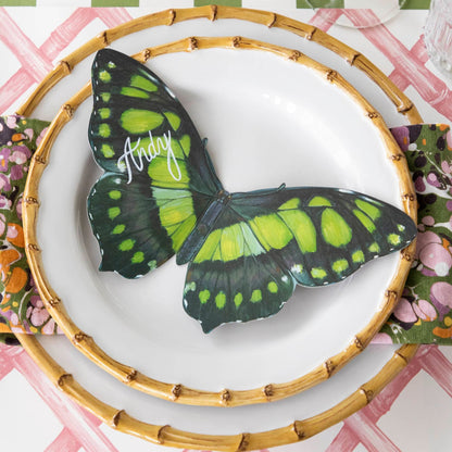 Butterfly Table Accent with &quot;Andy&quot; written in white ink on it, resting on bamboo dinner plates on an elegant place setting.