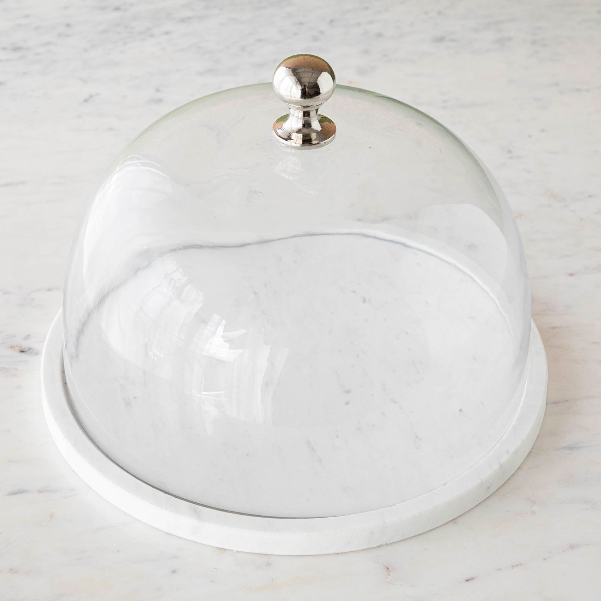 Chocolate muffins under a Bidk Home Marble &amp; Glass Food Dome with Knob, 11.5&quot; Diameter, presented on a white marble plate.