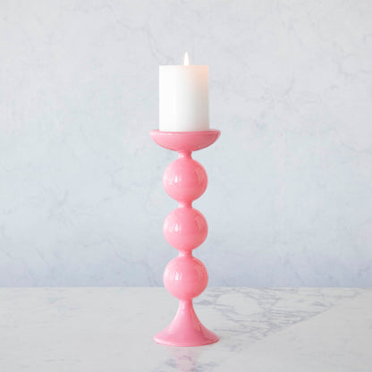A group of Glitterville Sweet Bubble Pillar Candle Holders in vibrant colors with a candle in the middle.