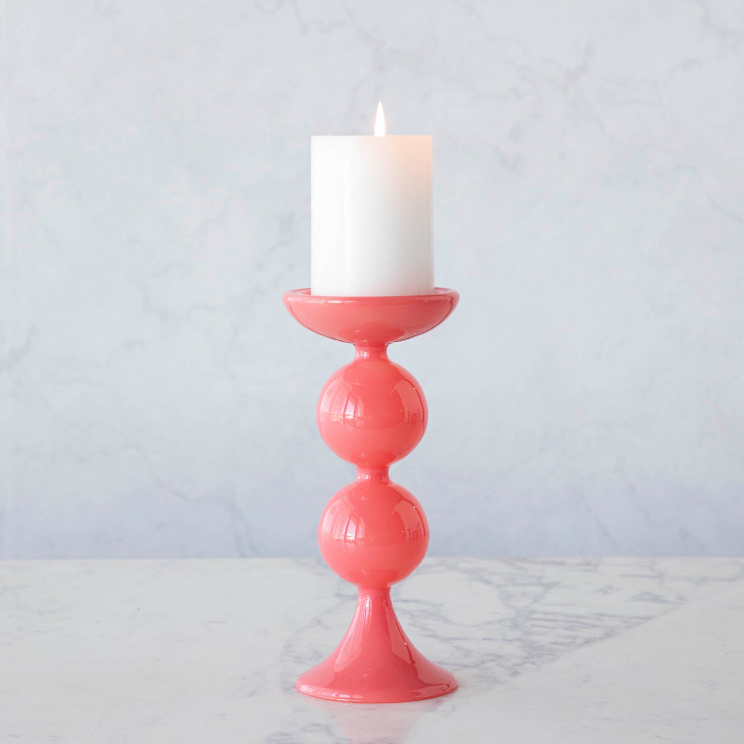 A group of Glitterville Sweet Bubble Pillar Candle Holders in vibrant colors with a candle in the middle.
