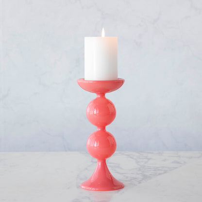 A group of Glitterville Sweet Bubble Pillar Candle Holders in vibrant colors with a candle in the middle.