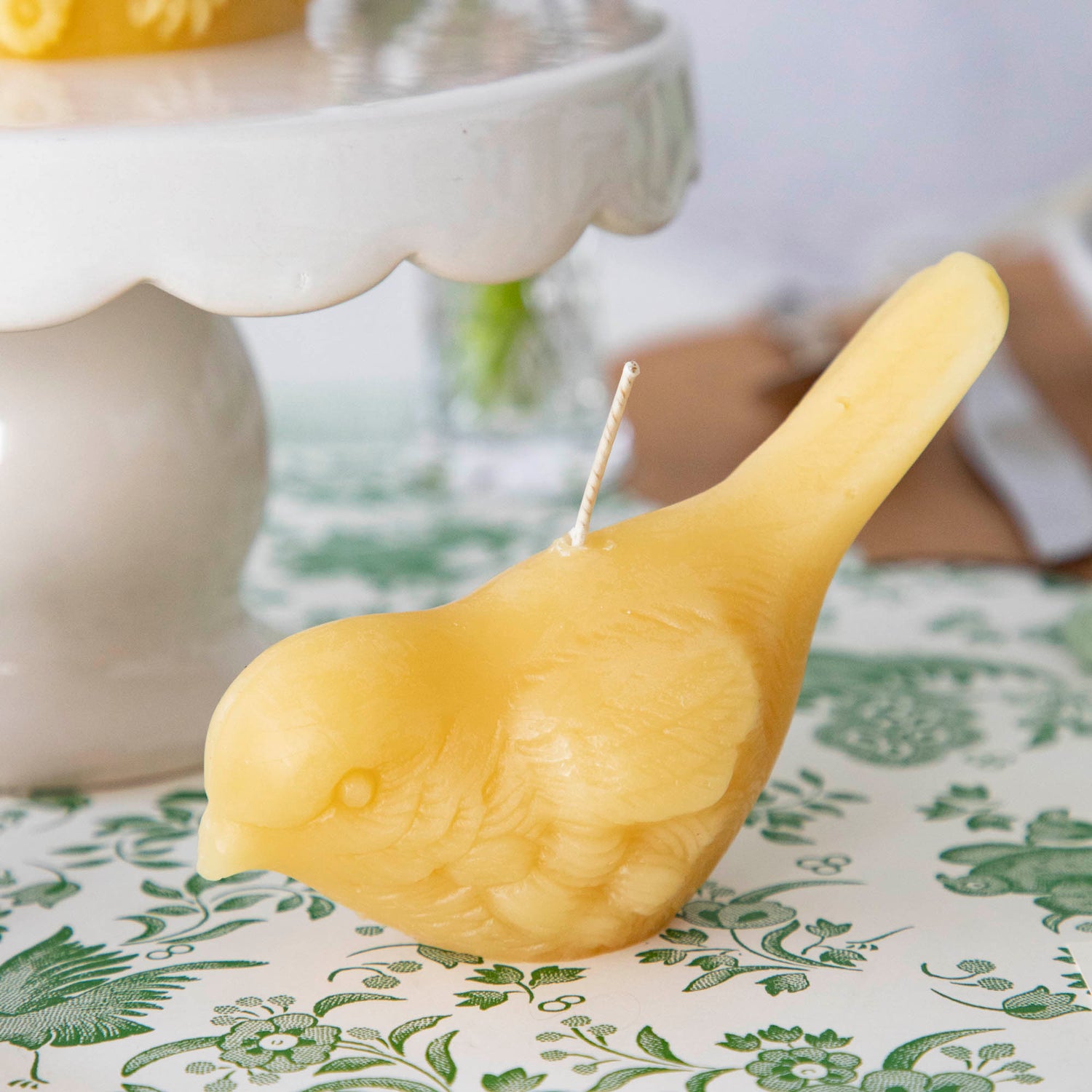 Two hand-casted Beeswax Songbirds Candles adorned with birds by Big Dipper Wax Works.