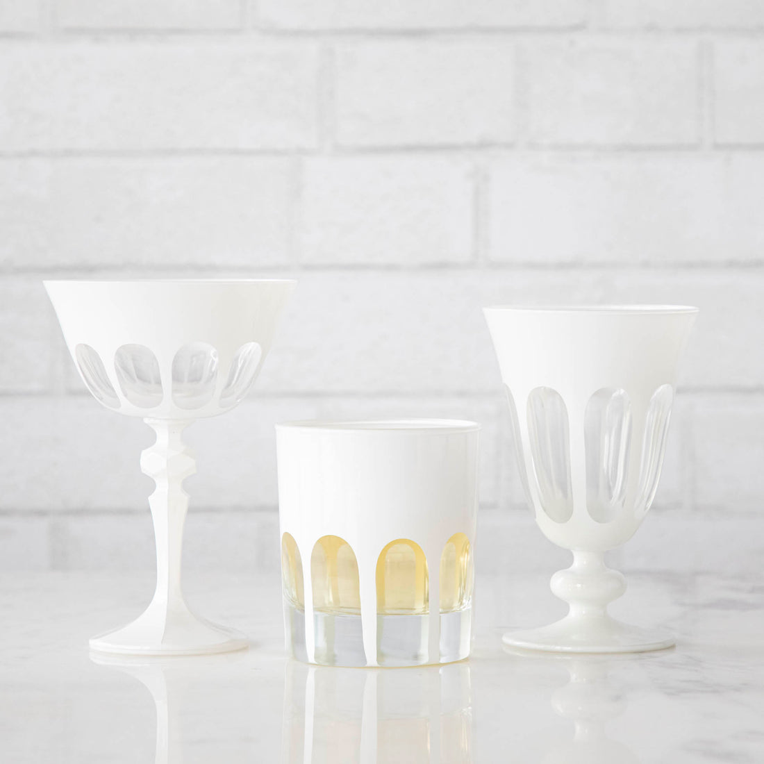 Three Rialto Chalk (White) Glasses by SIR/MADAM on a Venice-styled white brick wall.