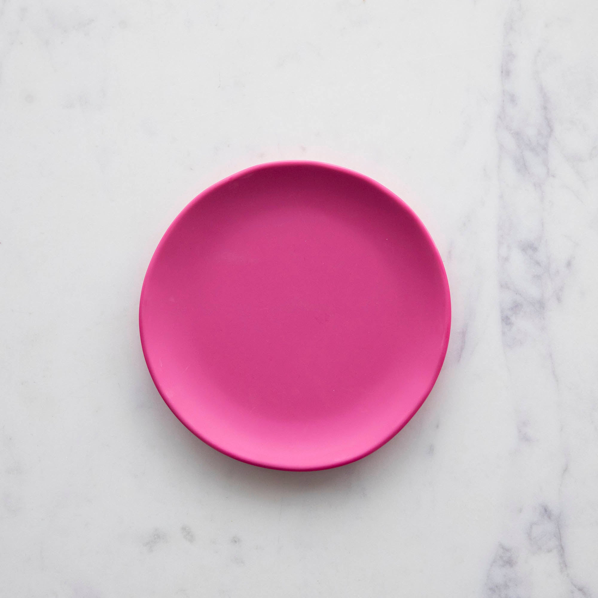 A 6&quot; glitter berry Rainbow Melamine Plate by Glitterville on a marble surface.