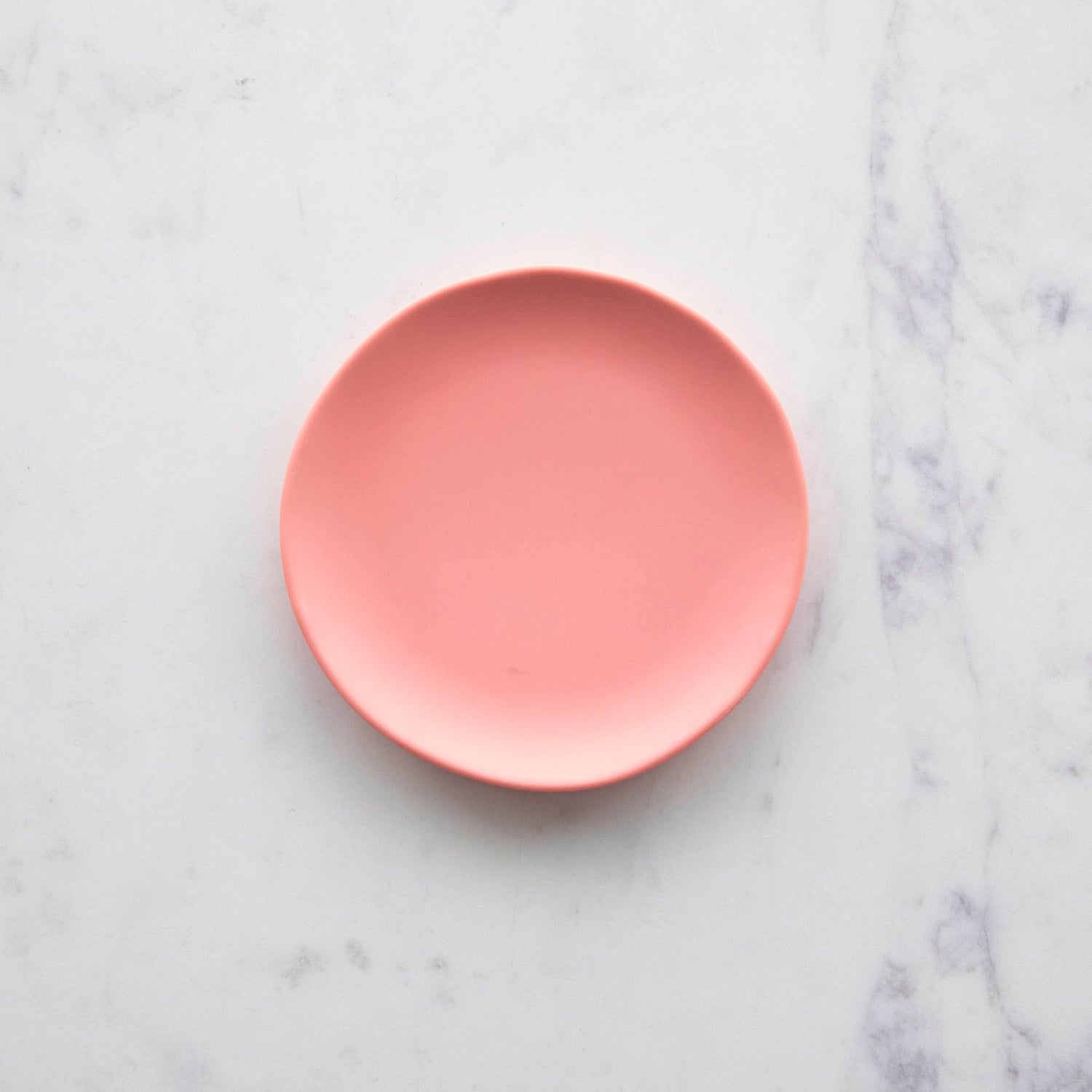 A colorful 6&quot; Rainbow Melamine Plate by Glitterville on a marble surface.