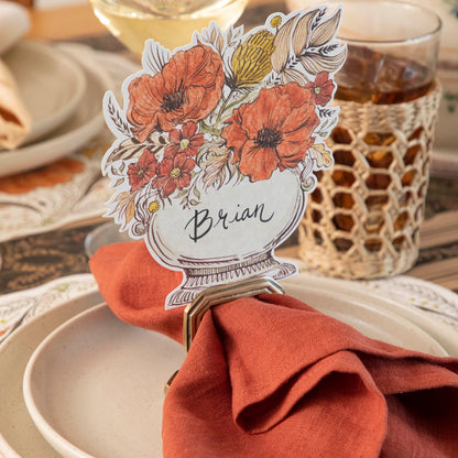 A close up view of the Autumn Arrangement Place Card with the name &quot;Brian&quot; written on it, on a fall themed table setting.
