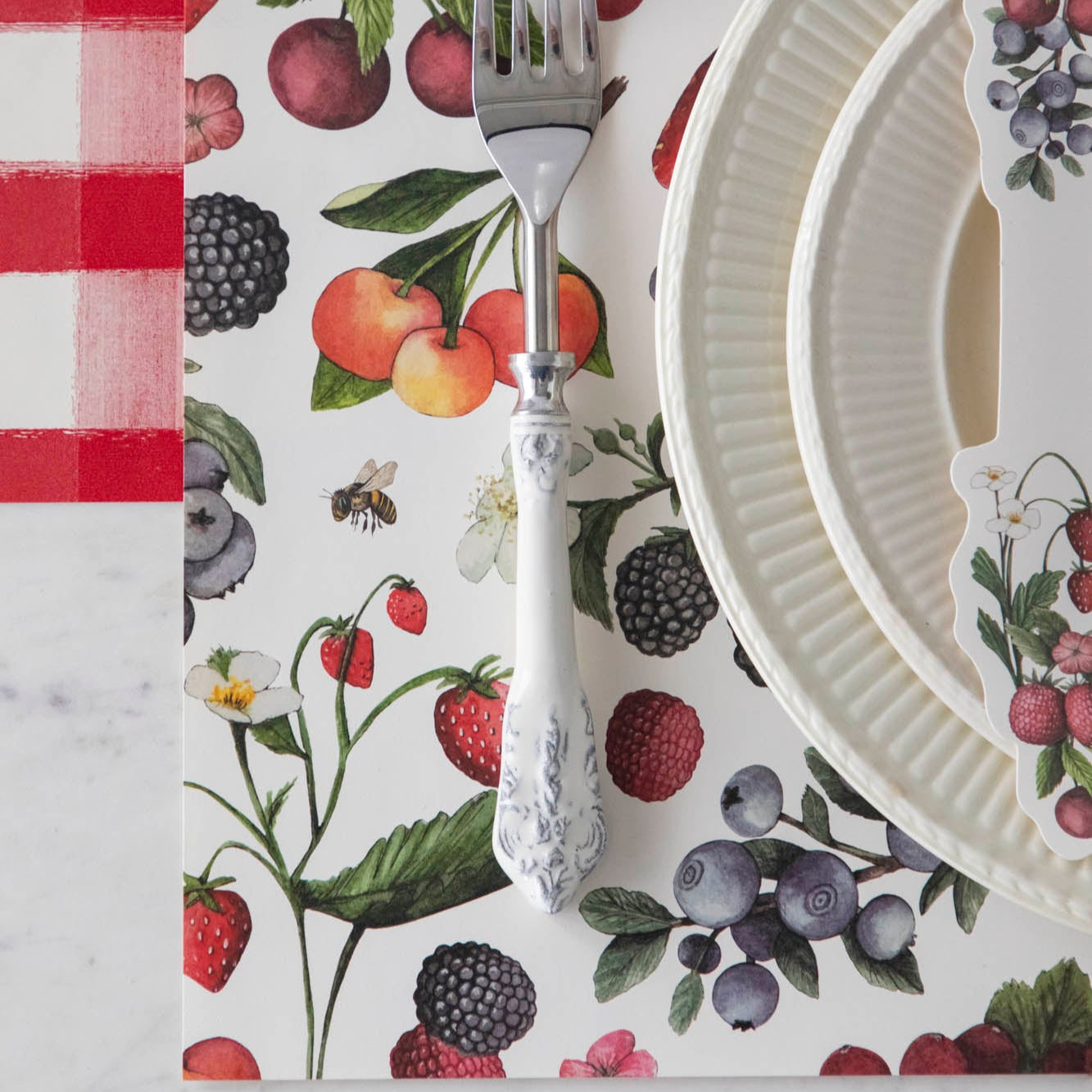 Close-up of the Wild Berry Placemat under an elegant summertime place setting, from above.