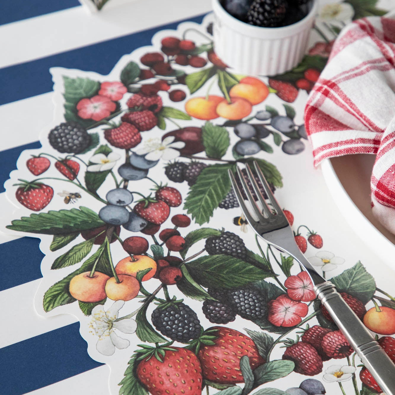 Close-up of the Die-cut Berry Wreath Placemat under an elegant place setting, showing the artwork in detail.