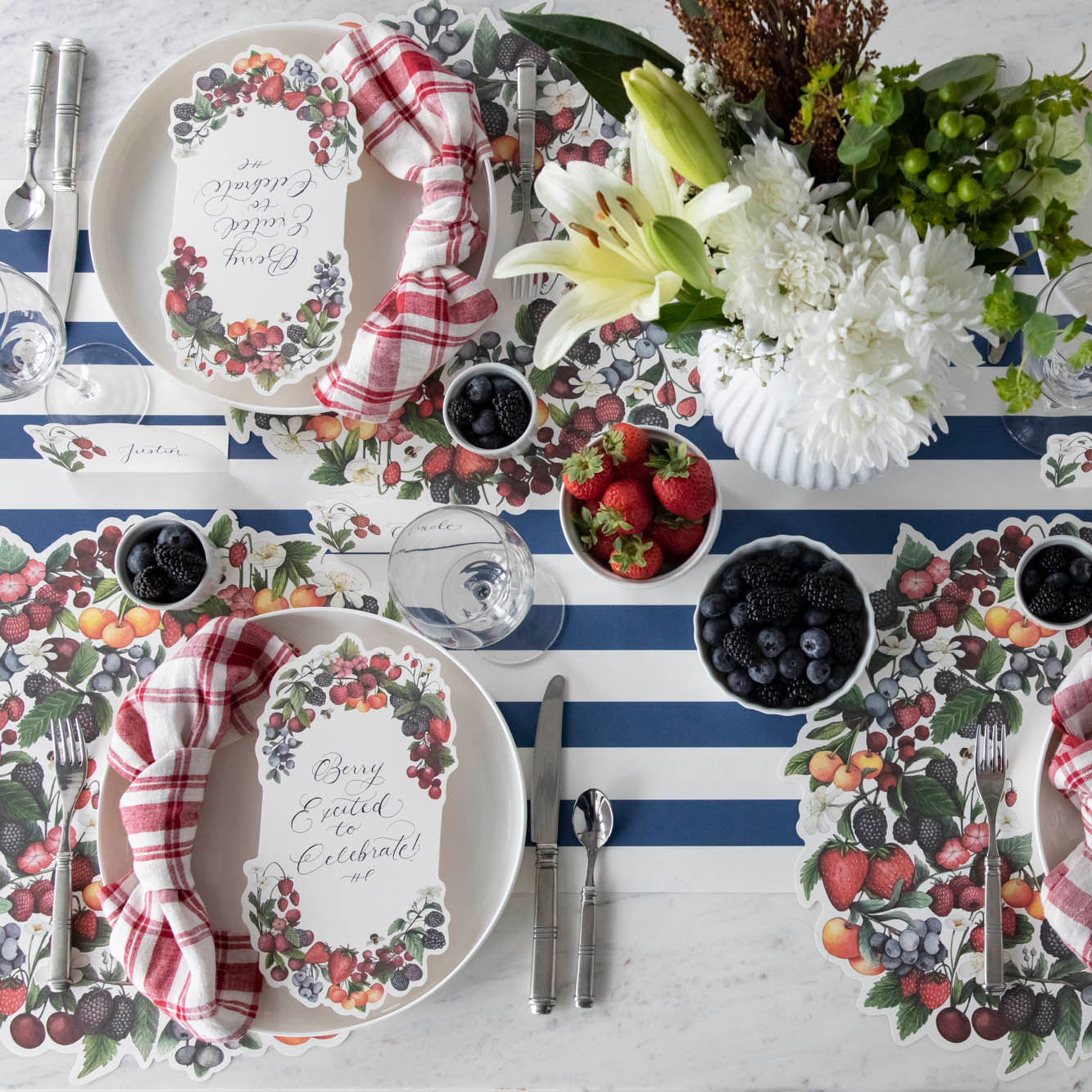 The Die-cut Berry Wreath Placemat under an elegant table setting for four, from above.