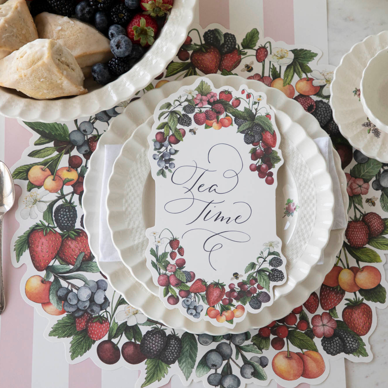 The Die-cut Berry Wreath Placemat under an elegant place setting, from above.