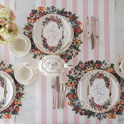 The Die-cut Berry Wreath Placemat under an elegant table setting for four, from above.