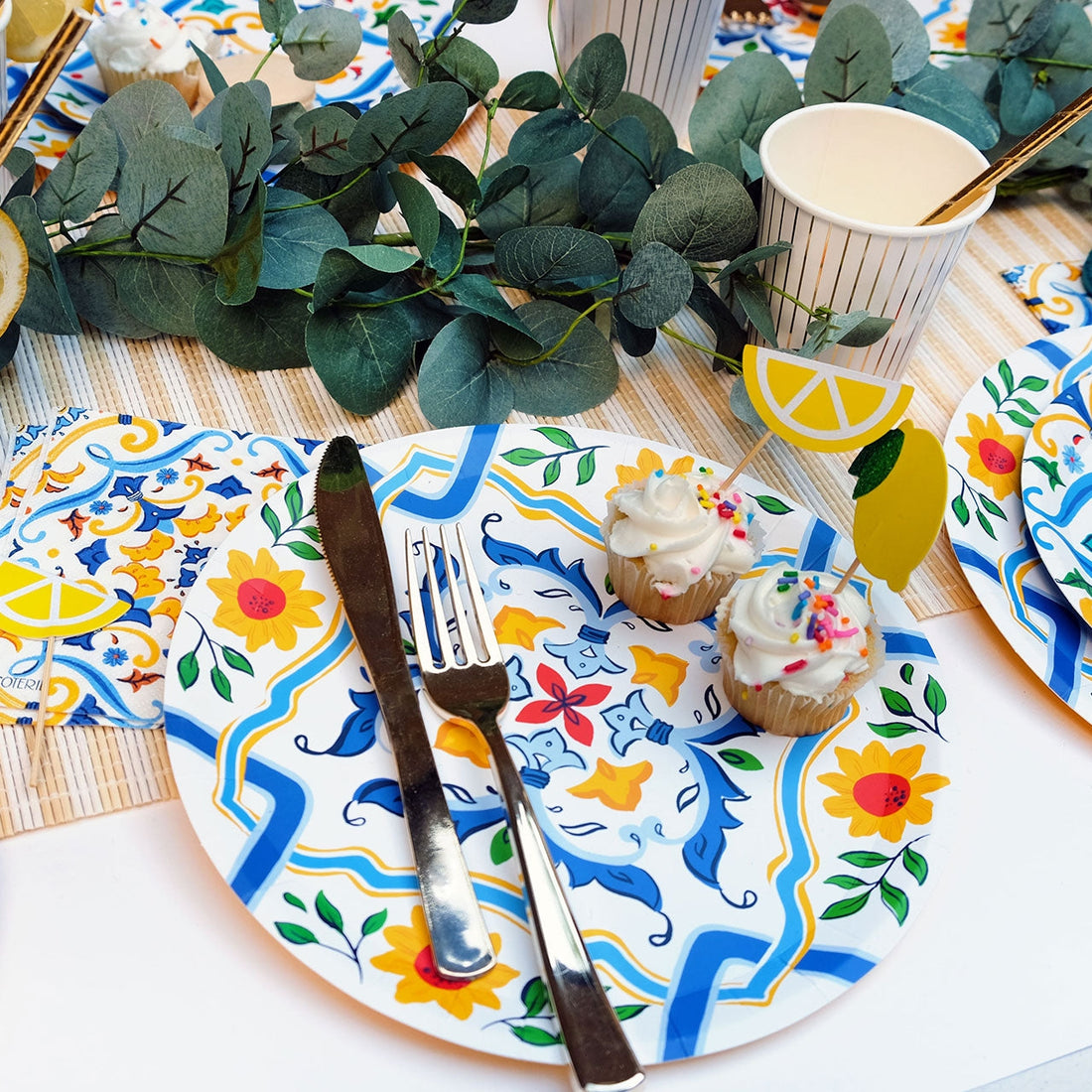 La Dolce Vita Paper Plate setting with cupcakes on it. 