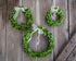 3 boxwood wreaths in 3 sizes hanging on a wood background. 