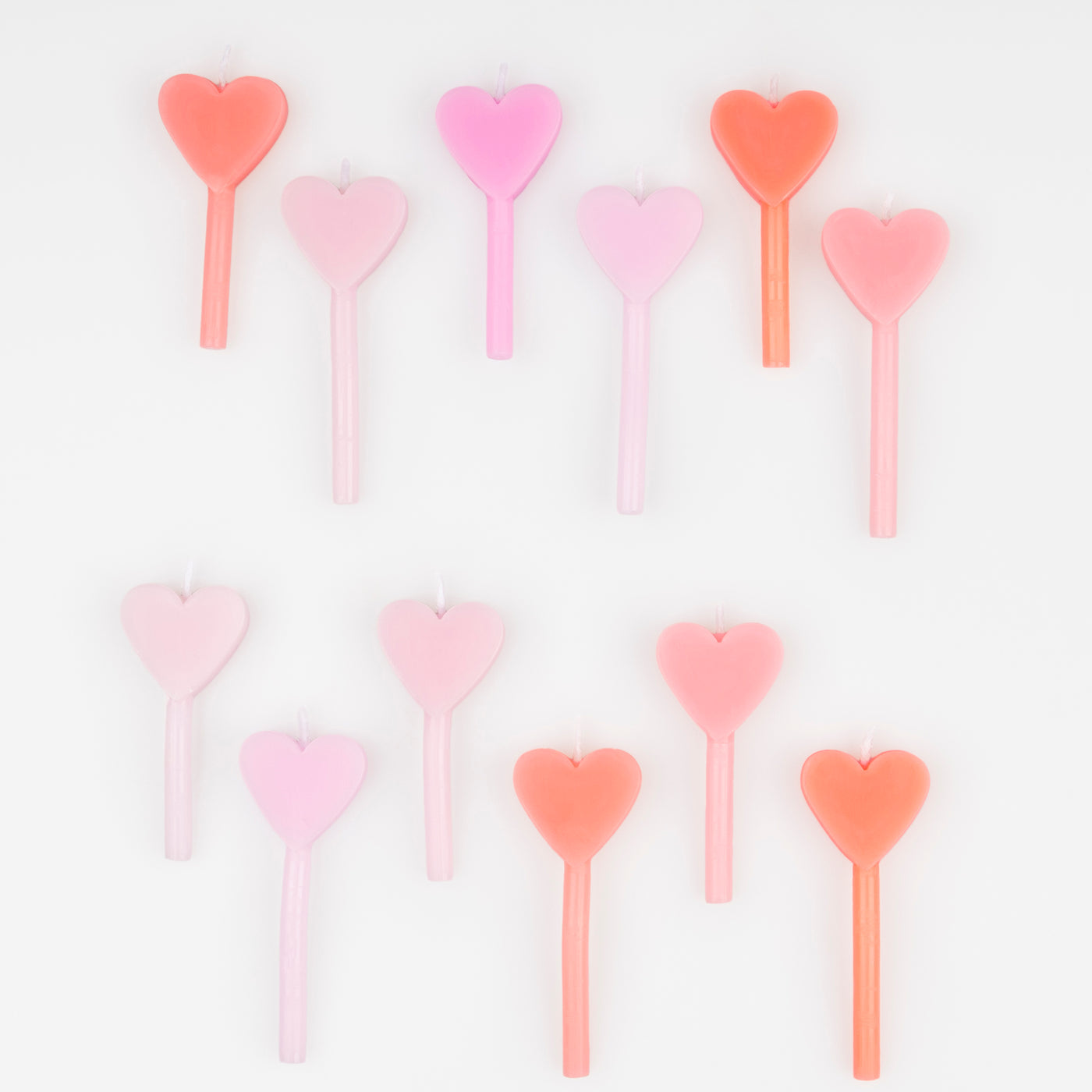 A set of 12 wax heart candles in 7 shades of pink by Meri Meri. 