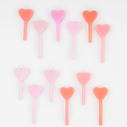 A set of 12 wax heart candles in 7 shades of pink by Meri Meri. 