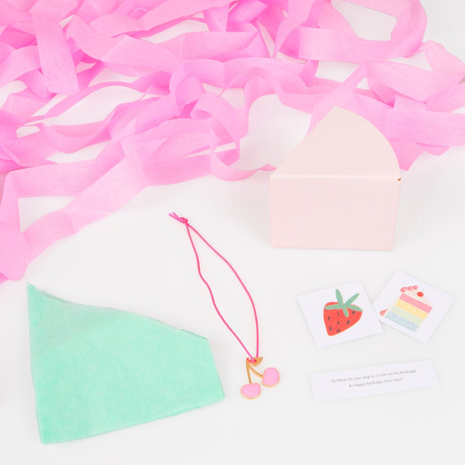 Inside each are 2 stickers, a joke, a mint tissue paper party hat and an enamel cherry charm, wrapped in white tissue paper
