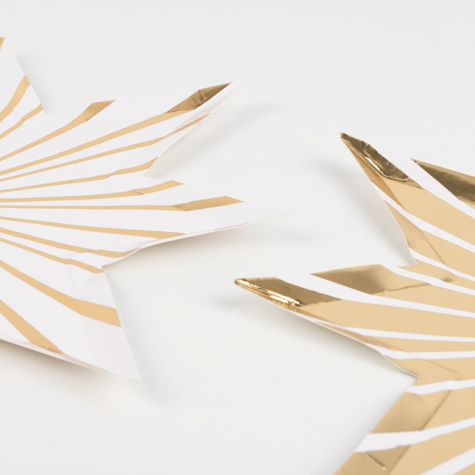 Two Meri Meri Gold Stripe Star Plates on a white background.