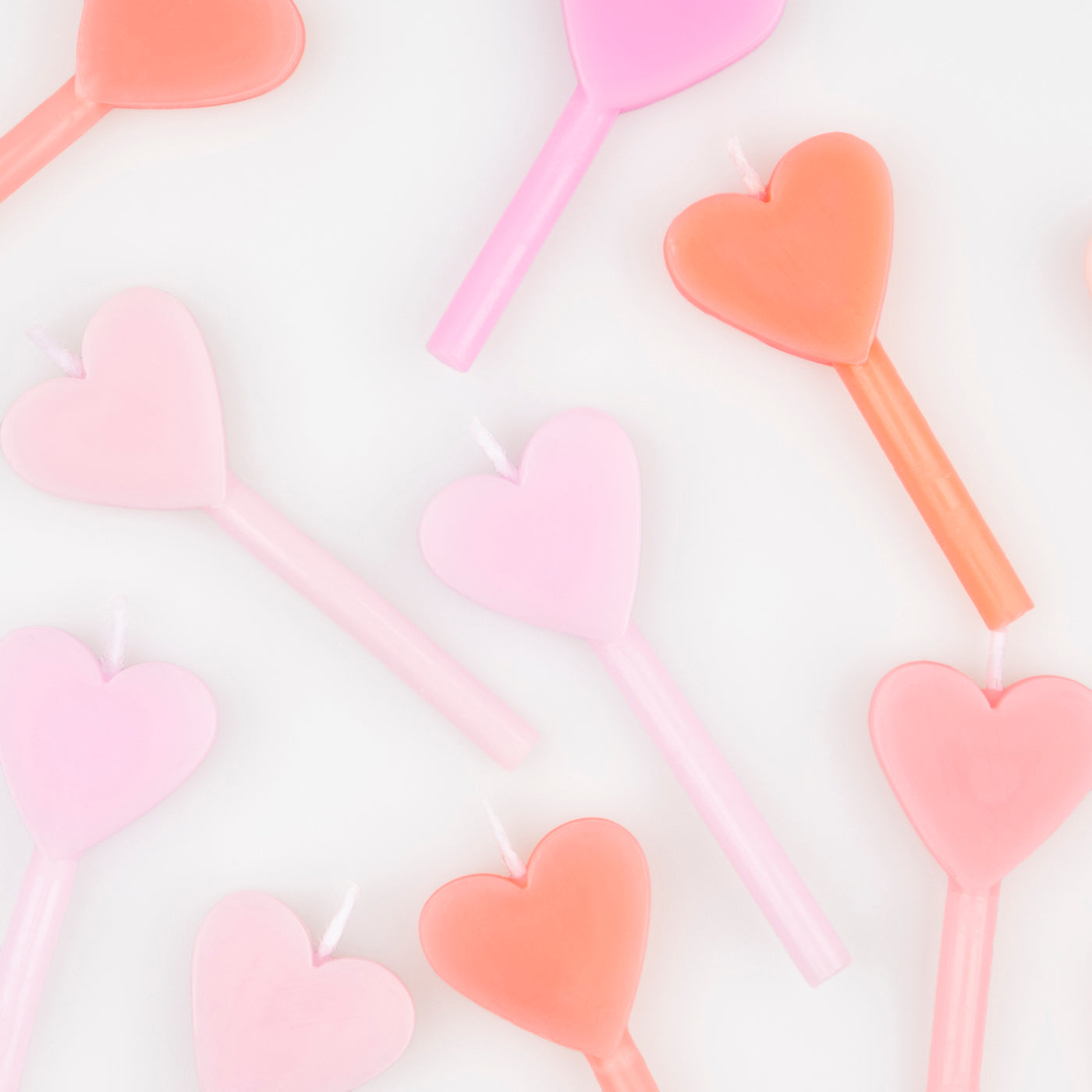 A set of 12 wax heart candles in 7 shades of pink by Meri Meri. 