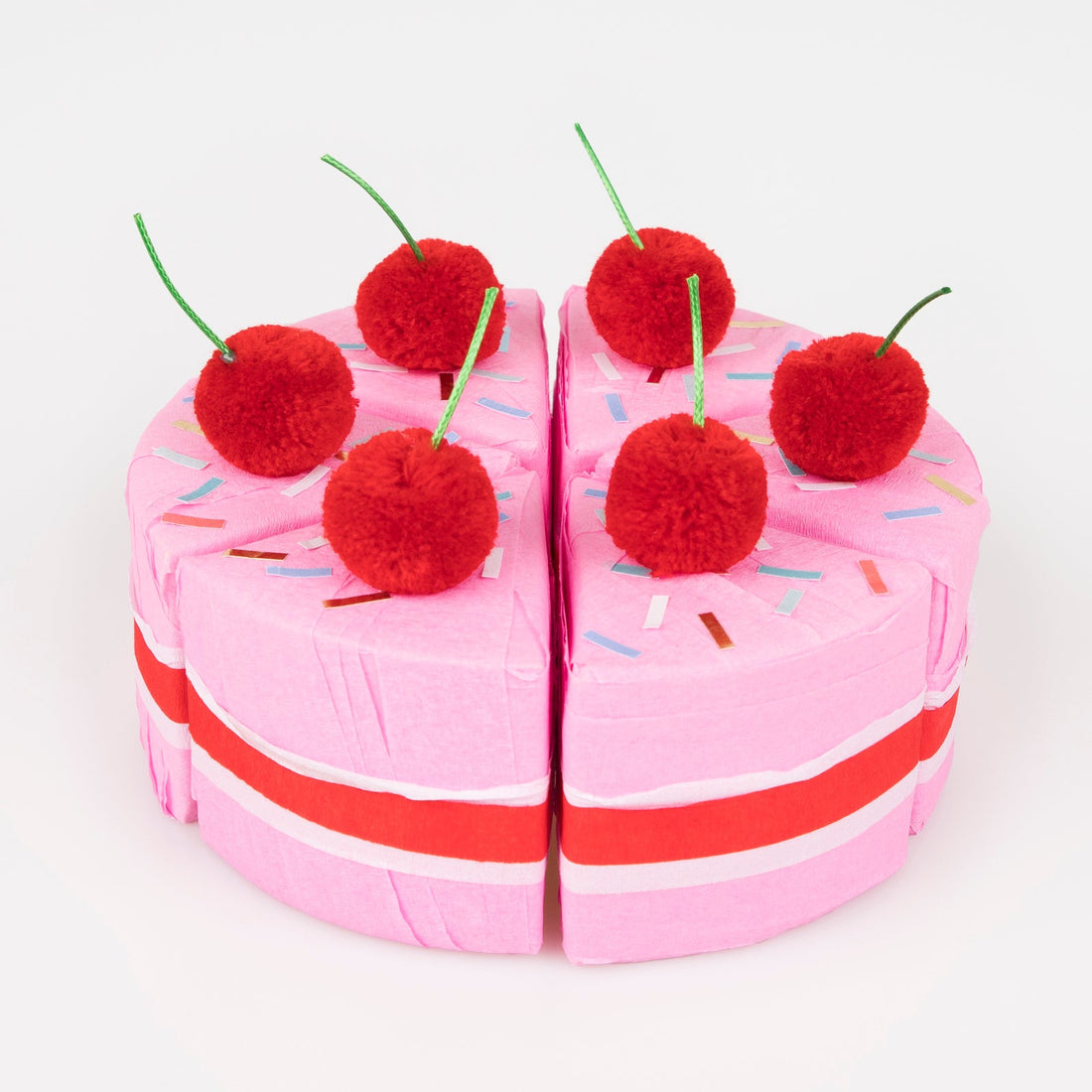 Meri Meri Surprise Cake Slices.  A box of 6 cakes slices crafted with red, white and pink crepe paper.  Each slice is topped with a red pompom cherry with a green cord stalk, and sprinkle stickers.