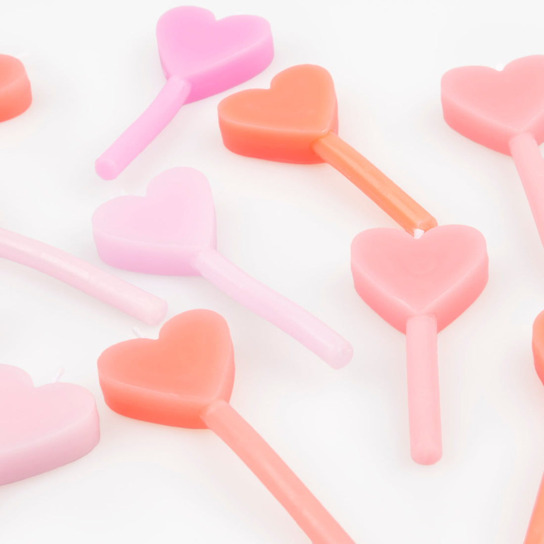 A set of 12 wax heart candles in 7 shades of pink by Meri Meri. 