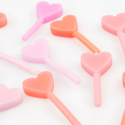 A set of 12 wax heart candles in 7 shades of pink by Meri Meri. 