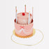 3D Paper hats in the shape of a cake with candles and red felt pom poms.