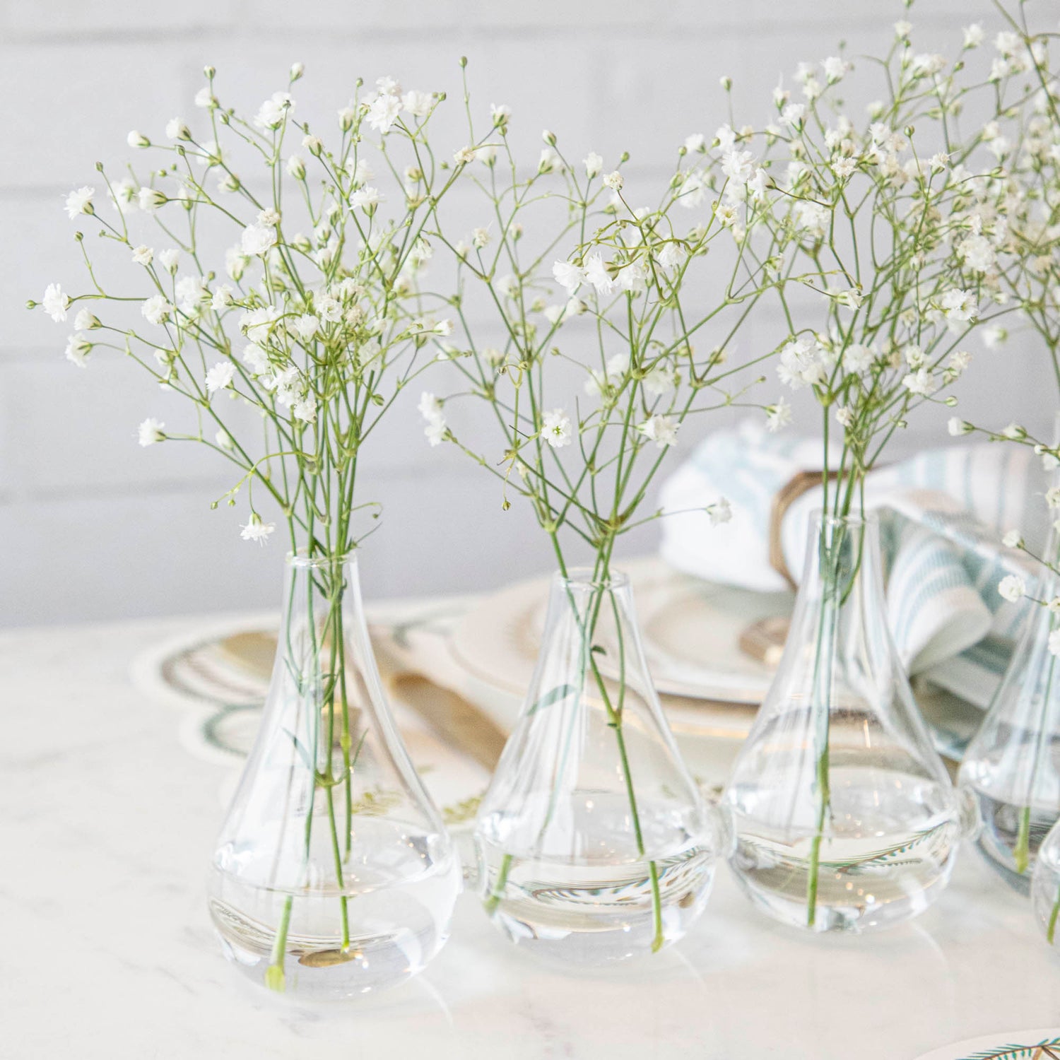 Five Quintet Glass Vases of varying shapes holding floral cuttings of pink roses and baby&
