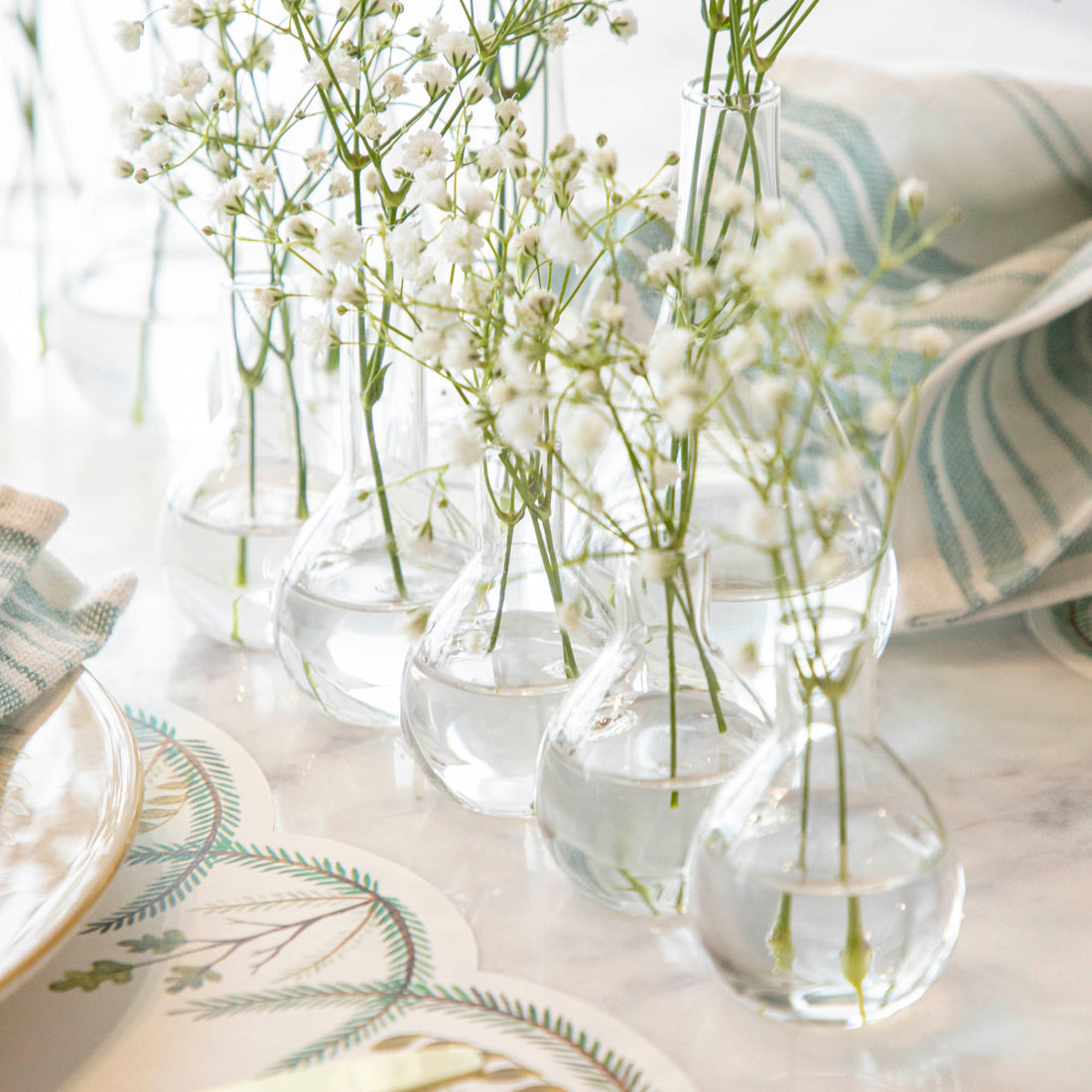 Five Quintet Glass Vases of varying shapes holding floral cuttings of pink roses and baby&