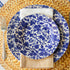 A Burleigh Blue Arden dinnerware plate on a wicker placemat with a folded napkin and a fork to the side, also noted as dishwasher safe.