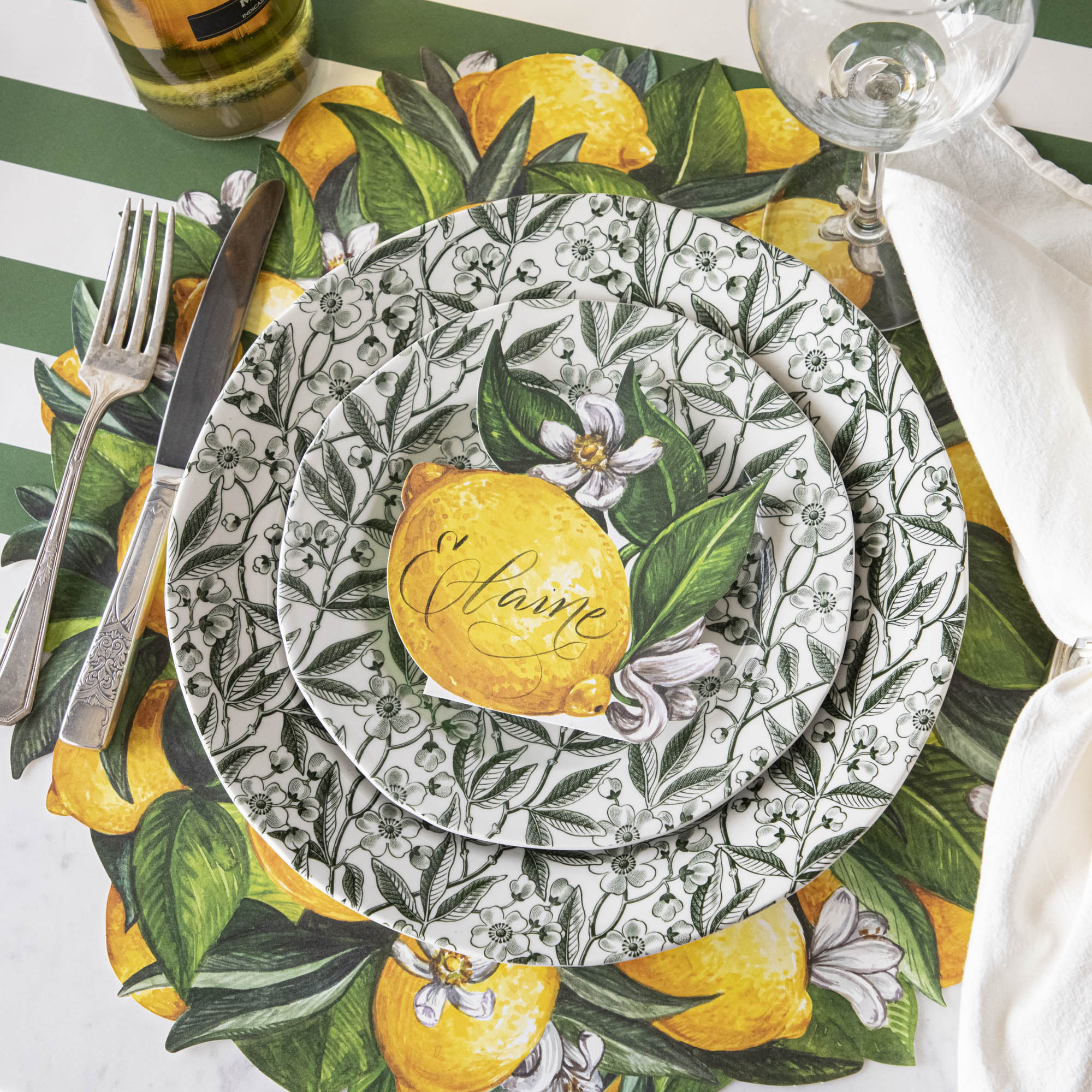 Elegant table setting with Burleigh Green Prunus Dinnerware plates and green striped tablecloth.